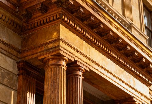 Фасад здания с классическими колоннами и резными архитектурными элементами