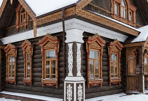 Русский стиль фасад: резные наличники на окнах и белый фасадный карниз из полиуретана