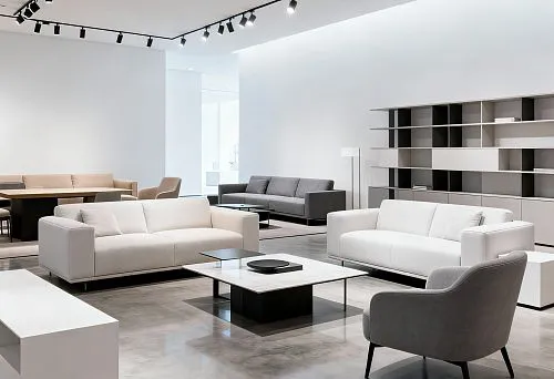 Современный мебельный салон с белыми и серыми диванами в минималистичном стиле