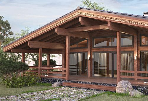 Дом в стиле русской усадьбы с декоративными элементами и резьбой на фасаде.