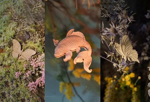 Пара деревянных рыбок, вырезанных из массива, подчеркивающих природные мотивы в оформлении интерьера