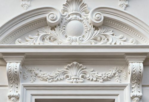 Фасадная лепнина с декоративными элементами над окном в классическом стиле