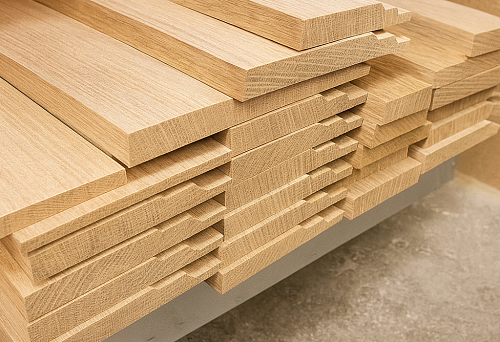 Стопка ровно нарезанных деревянных плинтусов из светлого дуба, подготовленных к установке в интерьере