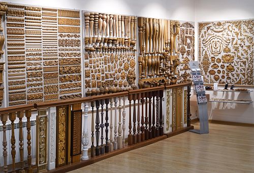 Стена с ассортиментом резных деревянных деталей, элементов декора, мебельных ножек, балясин и орнаментов