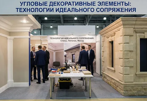 Выставочный стенд с образцами угловых элементов молдингов: интерьерные фрагменты стен и потолков с декоративными профилями слева