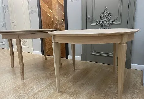 На фото представлены два округлых стола из натурального дерева с изящными ножками, демонстрирующие прочный каркас и утончённый дизайн.