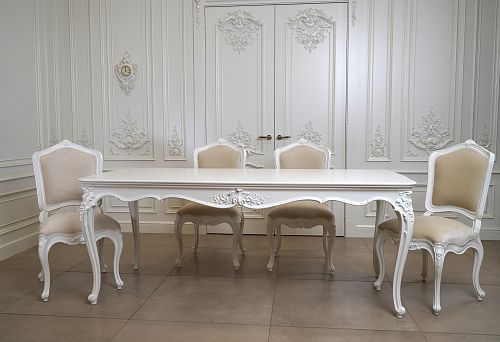 Изящные стулья под старину из массива дерева с мягкой обивкой на фоне светлого классического интерьера