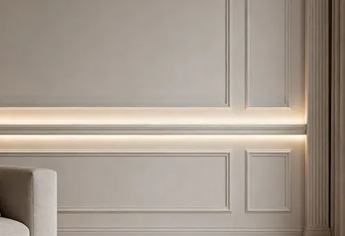 Современный интерьер с настенными молдингами и встроенной подсветкой, создающей мягкое рассеянное освещение по периметру стен.