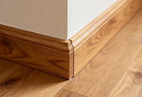 Плинтус из натурального дерева на полу крупным планом