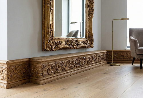 Современная квартира с дворцовой эстетикой: широкий резной деревянный плинтус с орнаментом вдоль стены