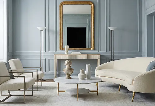 Мебель в неоклассическом стиле: кремовый диван на тонких латунных ножках в светлой гостиной