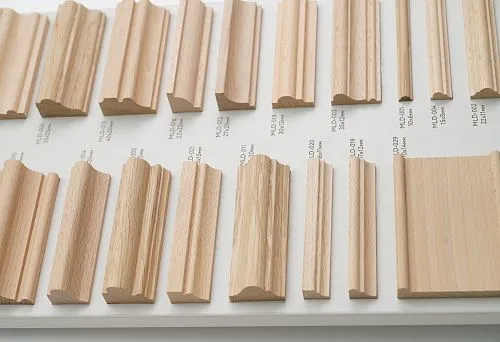 Образцы декоративных деревянных реек разных форм и размеров на стенде, с маркировкой профилей и сечений