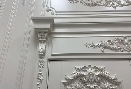 Белоснежное декоративное обрамление дверного проёма с лепным декором и изящными архитектурными формами в классическом стиле интерьера