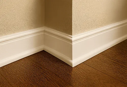 Белый массивный плинтус на стыке деревянного пола и стены в интерьере