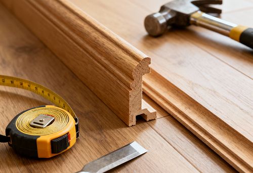 Профиль плинтуса из дуба в процессе монтажа.