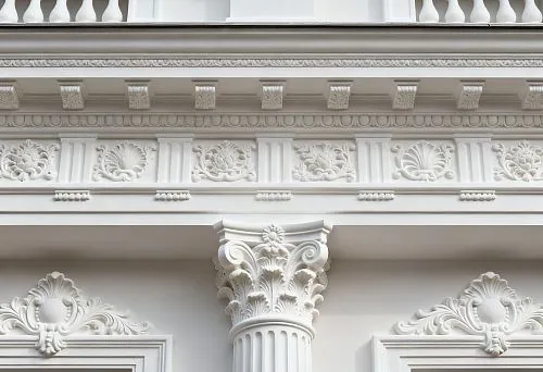 Фасадный декор СПб с колонной и резными элементами на белом фасаде здания