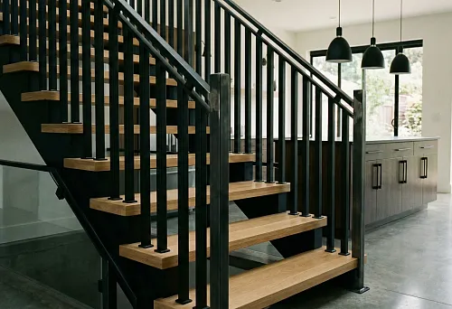 Лестница с выразительными деревянными балясинами и контрастными тёмными акцентами