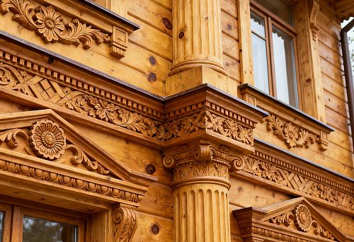 Фасадный декор из дерева с резными колоннами и наличниками