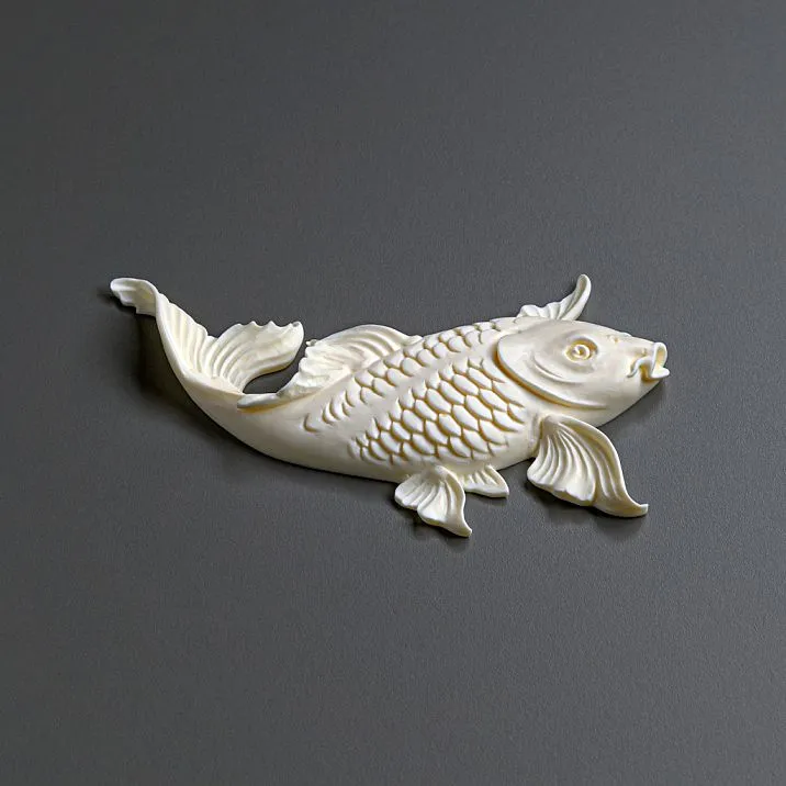 Элегантный интерьер с голубым комодом, декорированным лепниной в виде рыб и растительных элементов.