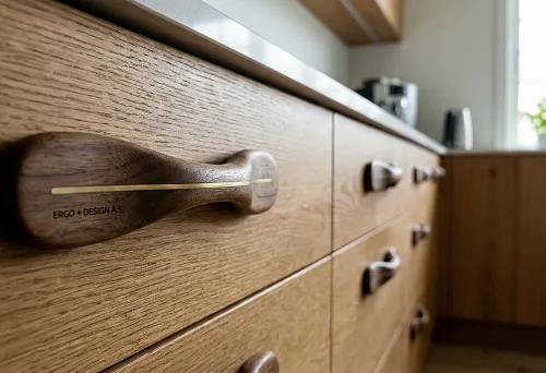 Деревянная мебельная ручка с латунной вставкой на кухонном фасаде из массива.